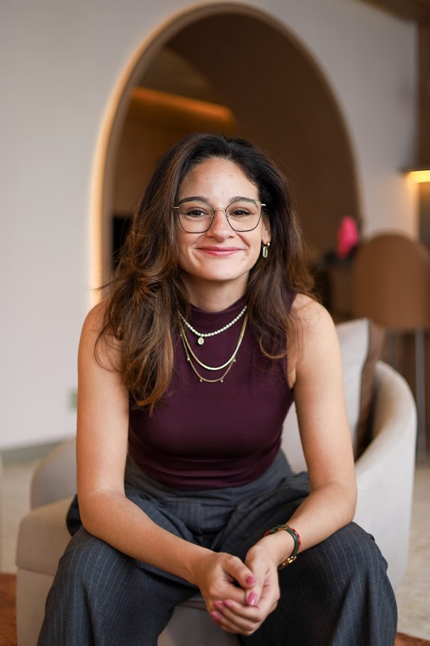 Olívia Sensata sentada em uma poltrona